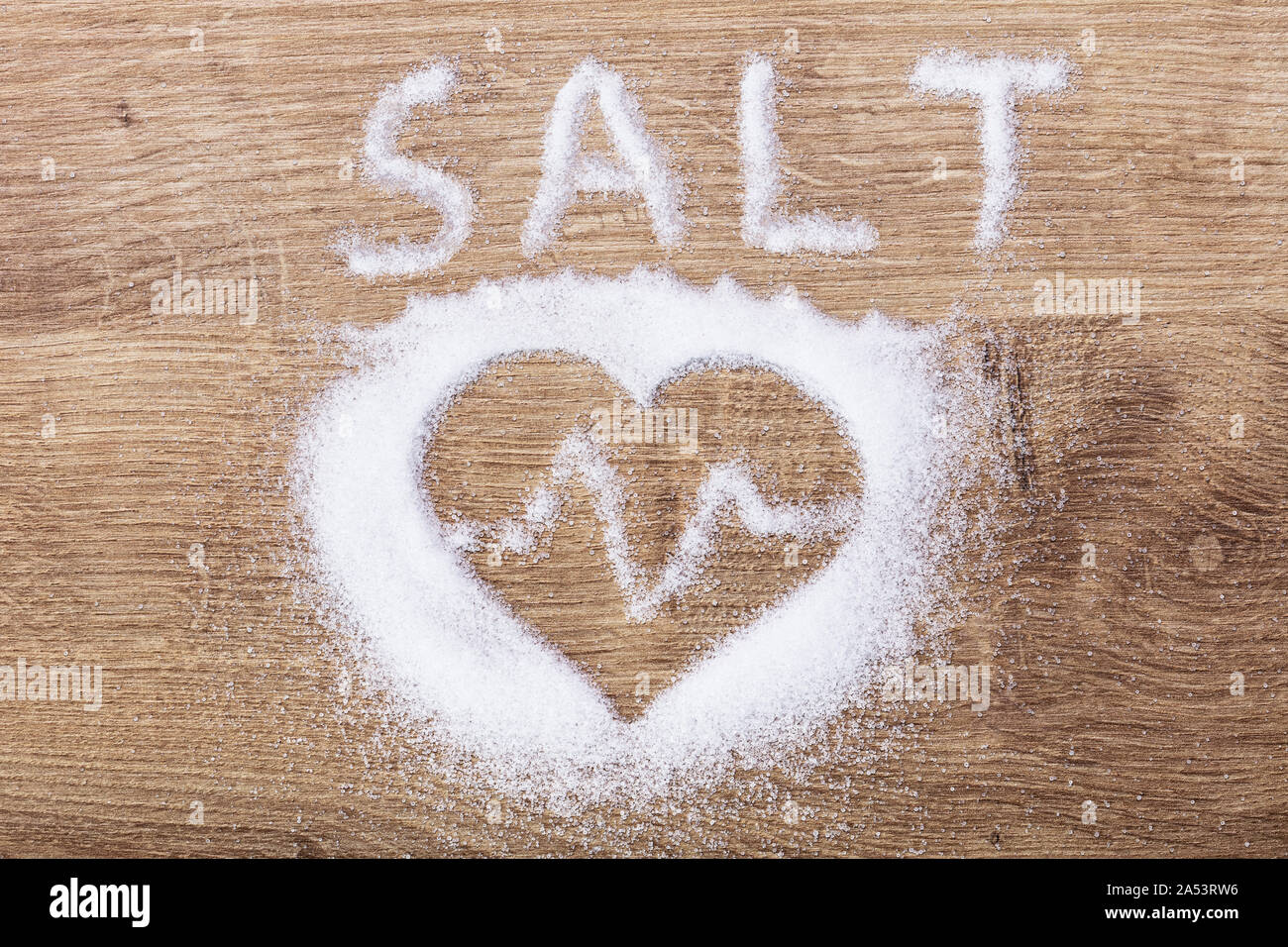 Salz und Herzen mit Heartbeat mit Salz auf hölzernen Schreibtisch Stockfoto