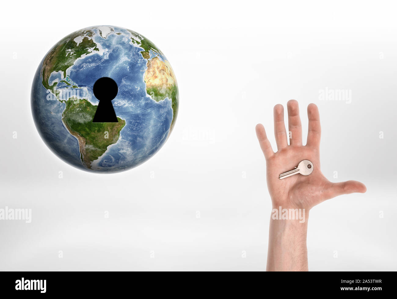 Menschliche Hand mit dem Schlüssel vom Planeten Erde. Stockfoto