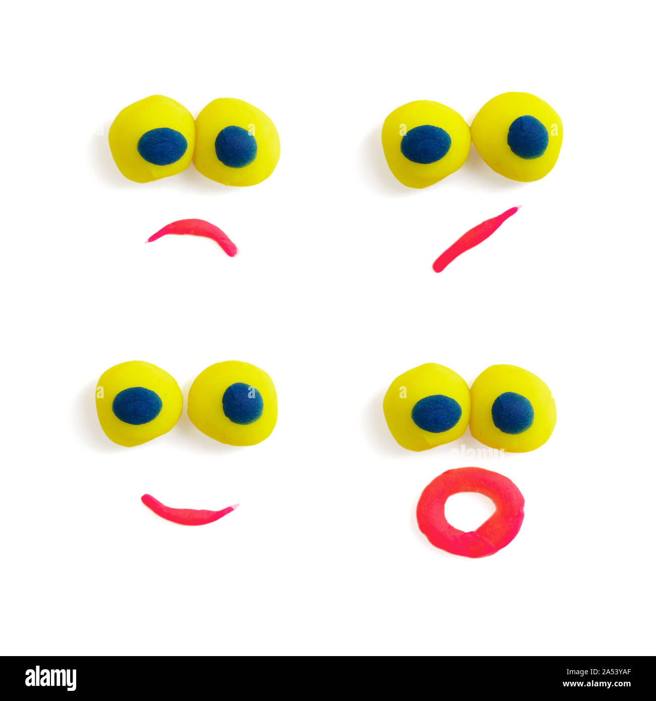 Vier lustige Gesichter - Augen und Mund - aus bunten Knetmasse mit unterschiedlichen Ausdrücke auf dem weißen Hintergrund. Stockfoto
