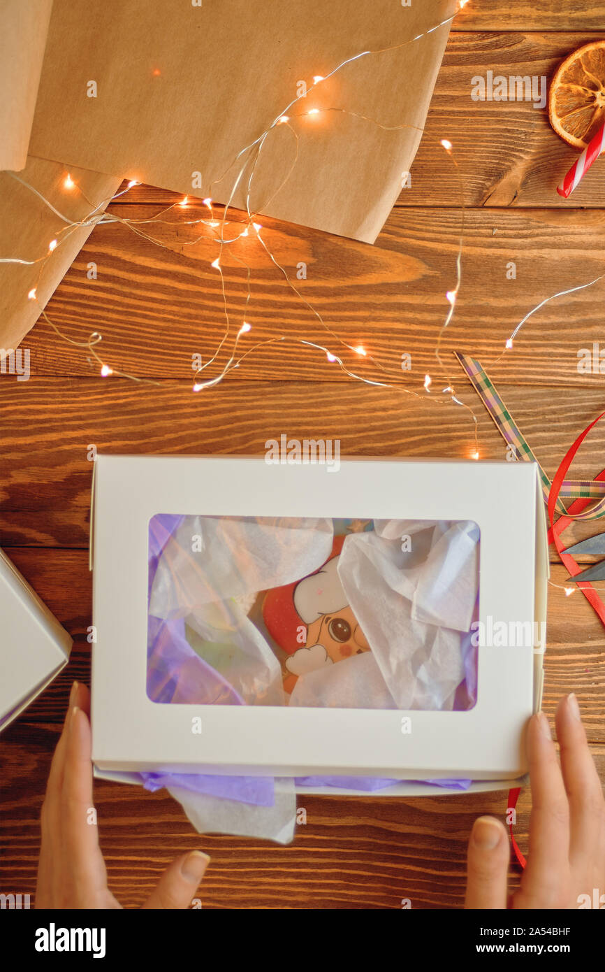 Neue Jahr Geschenk. Womanan holding Weihnachtsgeschenke auf einer hölzernen Tisch Hintergrund Stockfoto