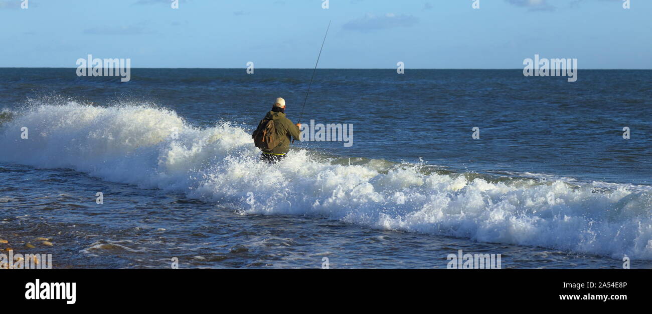 Angeln in der Nähe von Seaton Fliegen in Devon. Fischer von Wave hit. Stockfoto