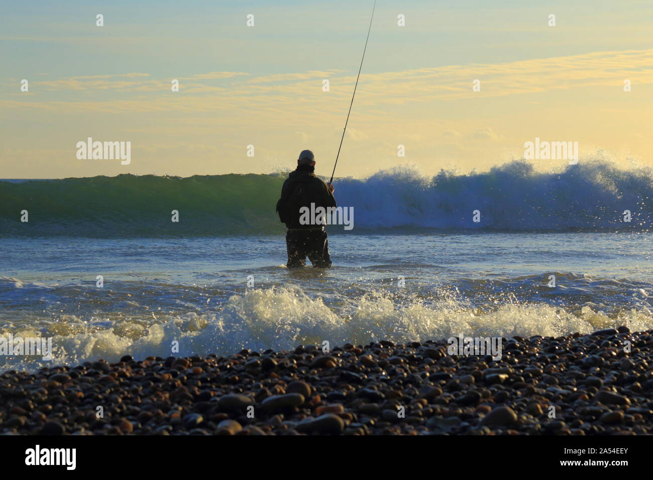 Angeln in der Nähe von Seaton Fliegen in Devon. Fischer von Wave hit. Stockfoto