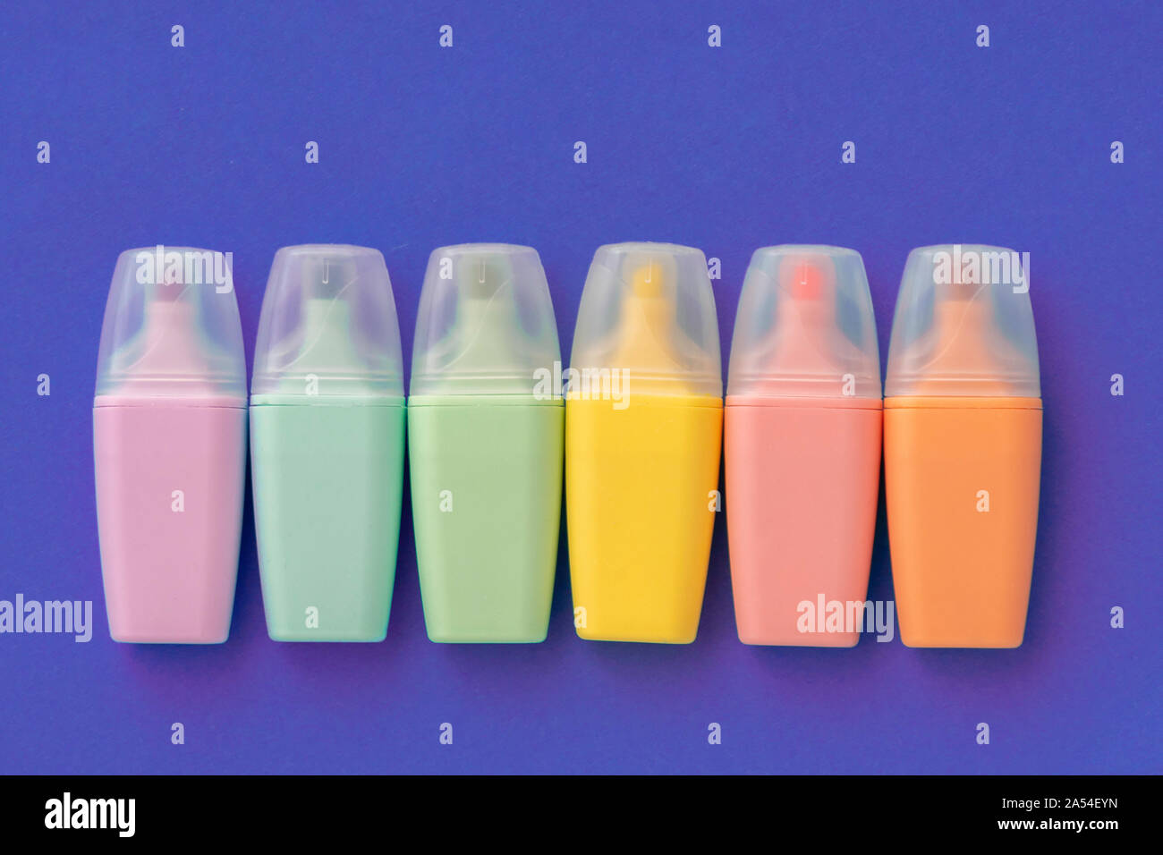 Textmarker auf farbigen violette Hintergrund gesetzt. Sammlung von Markierungen in verschiedenen Farben. Flach, Ansicht von oben. Zurück zu Schule, Bildung Konzept. Stockfoto