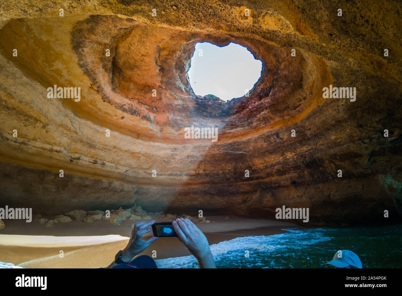 Ein Tourist, der ein Bild von Benagil Höhle auf einer Bootsfahrt, Algarve, Portugal Stockfoto