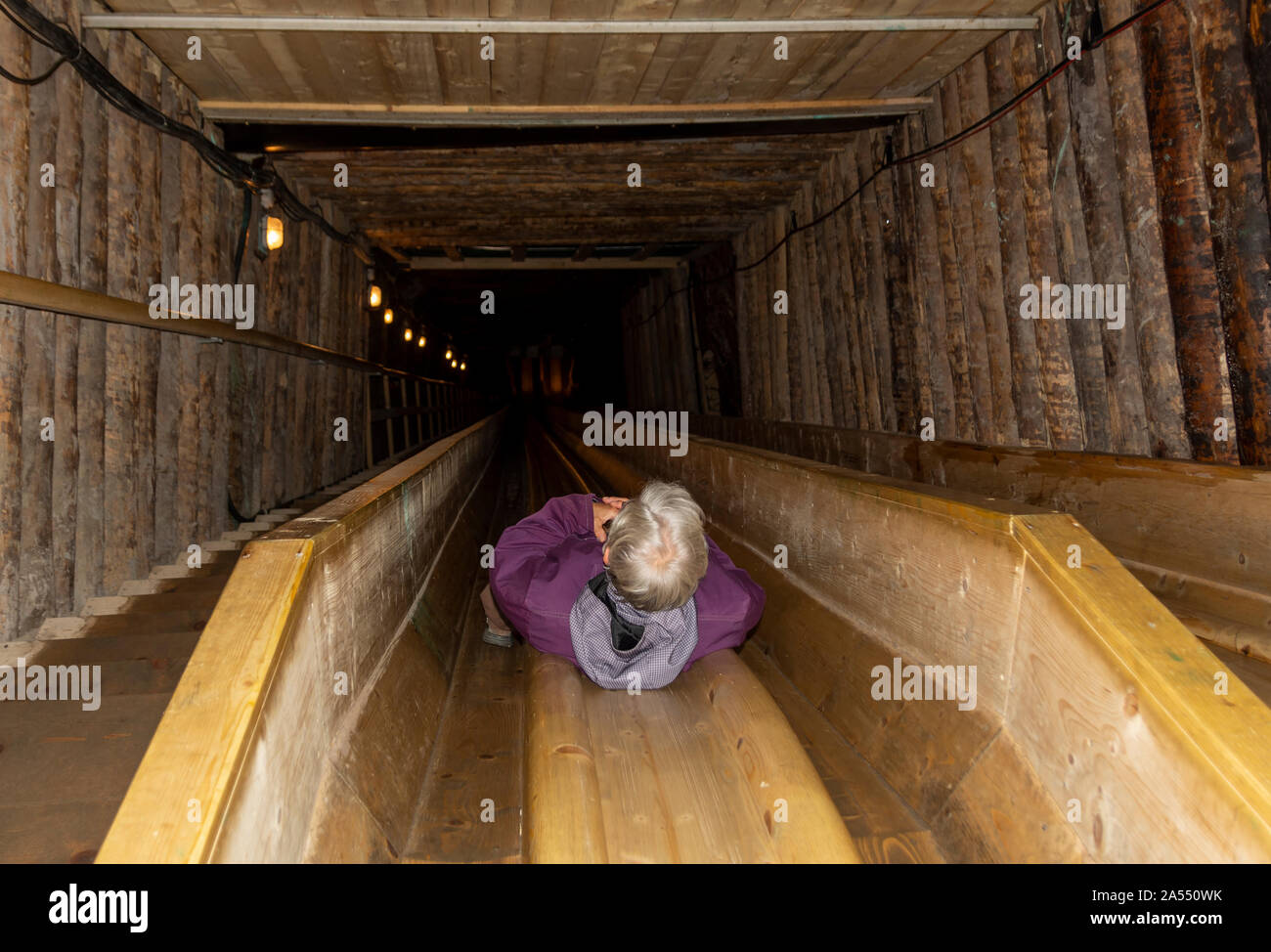 Frauen nimmt eine schnelle slade Weg zum unteren Teil des Salzbergwerk in Hallstatt. Stockfoto