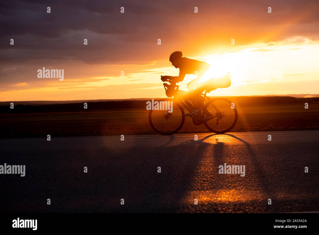 Bikepacking auf einer Straße in der Wüste im Iran bei Sonnenuntergang. Stockfoto