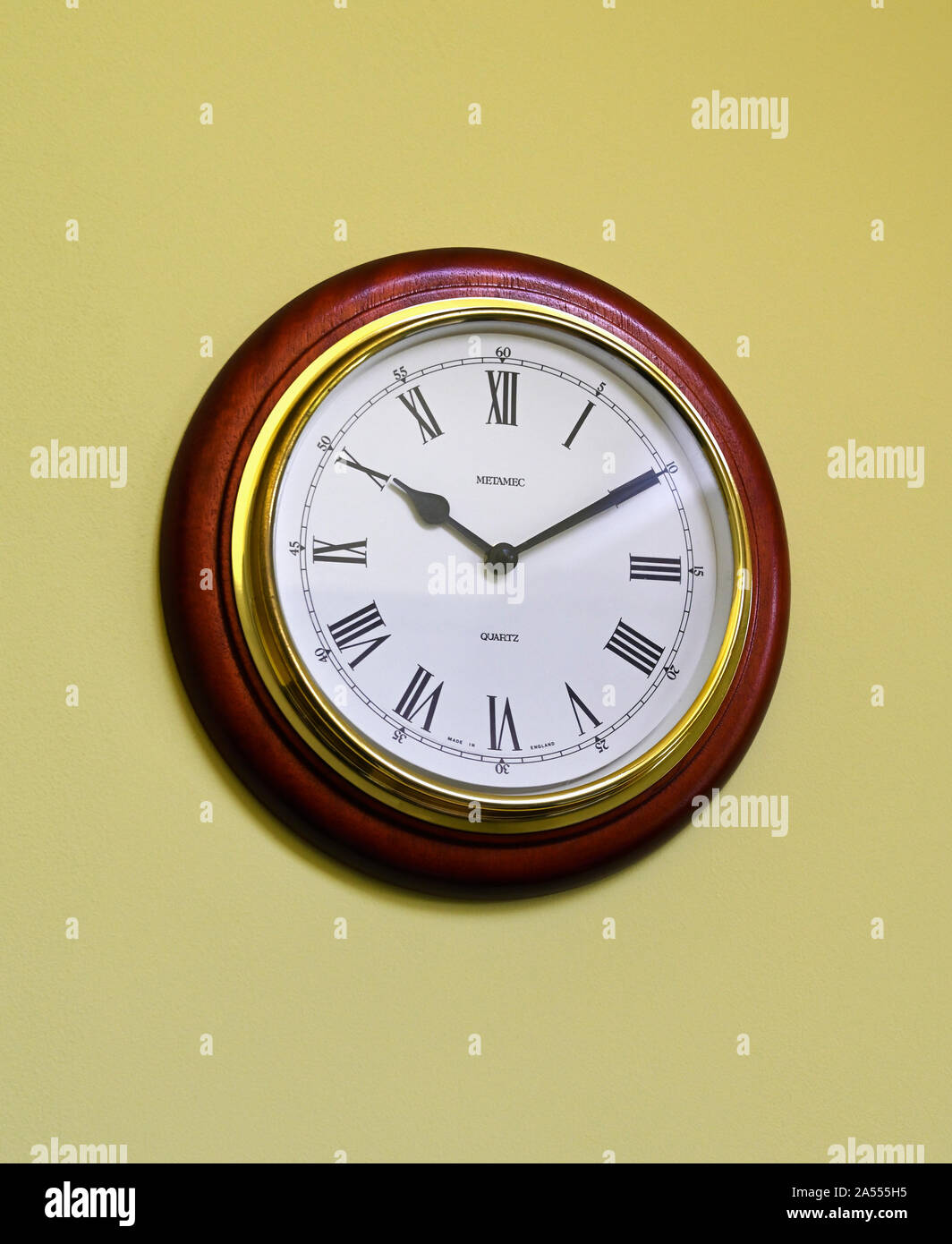 An der Wand montiert, batteriebetriebener Metamec Quarzuhr. In England hergestellt. Römische Ziffern. Stockfoto