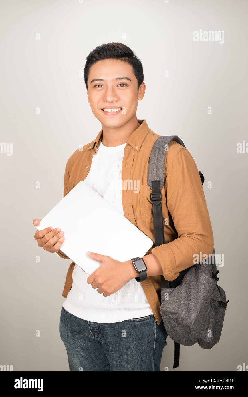 Portrait von asiatischen Teenager college Boy holding Bücher und Dokumente gegen weißen Hintergrund Stockfoto