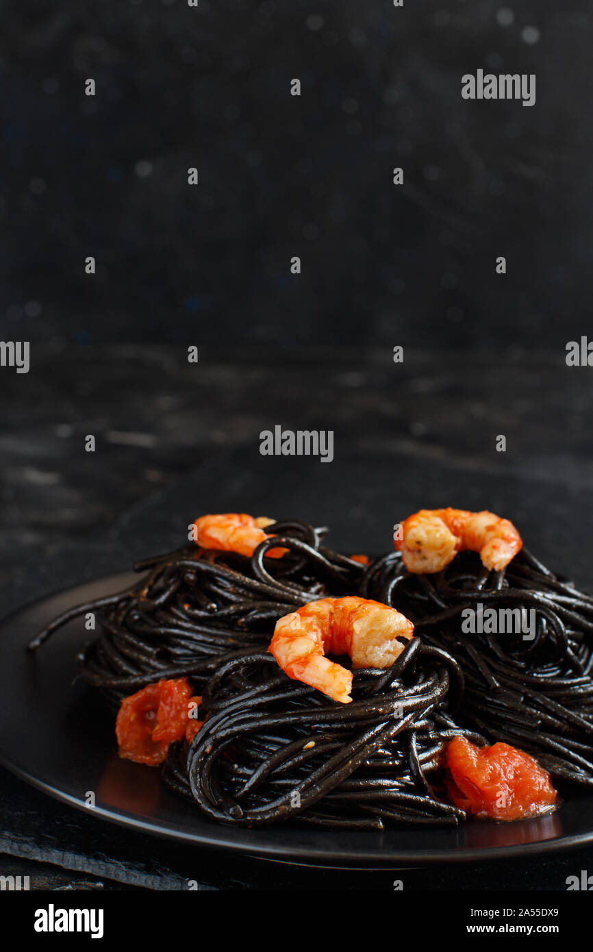 Tintenfisch schwarze Spaghetti mit Garnelen und Tomaten Nahaufnahme Stockfoto