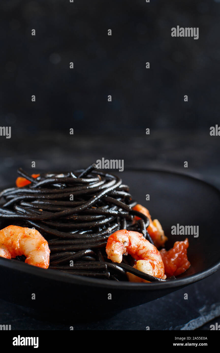 Tintenfisch schwarze Spaghetti mit Garnelen und Tomaten Nahaufnahme Stockfoto