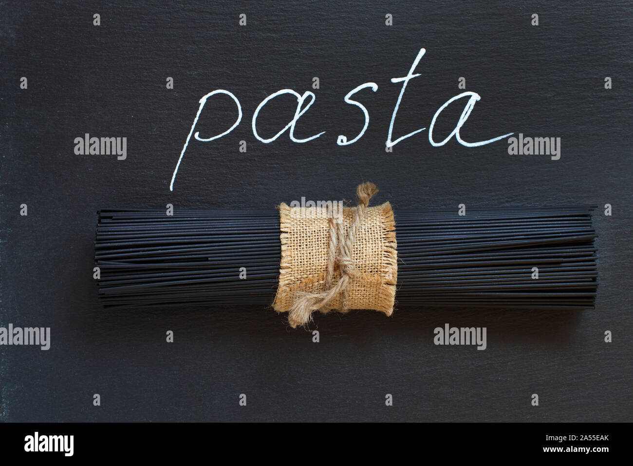 Rohen Tintenfisch schwarze Spaghetti auf schwarzem Schiefer Draufsicht Stockfoto