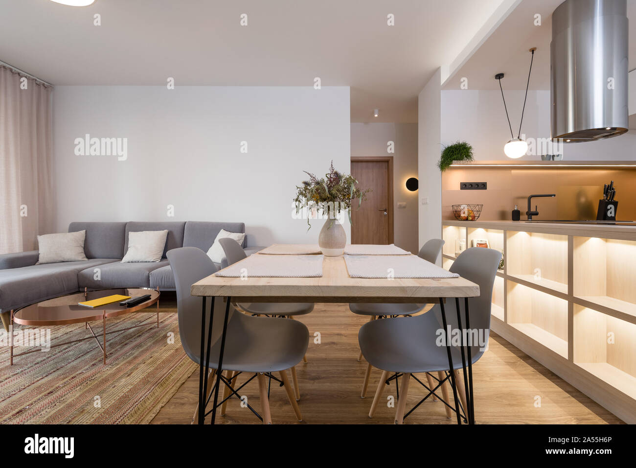 Esstisch zwischen Küche und Wohnzimmer in einem modernen Apartment Stockfoto
