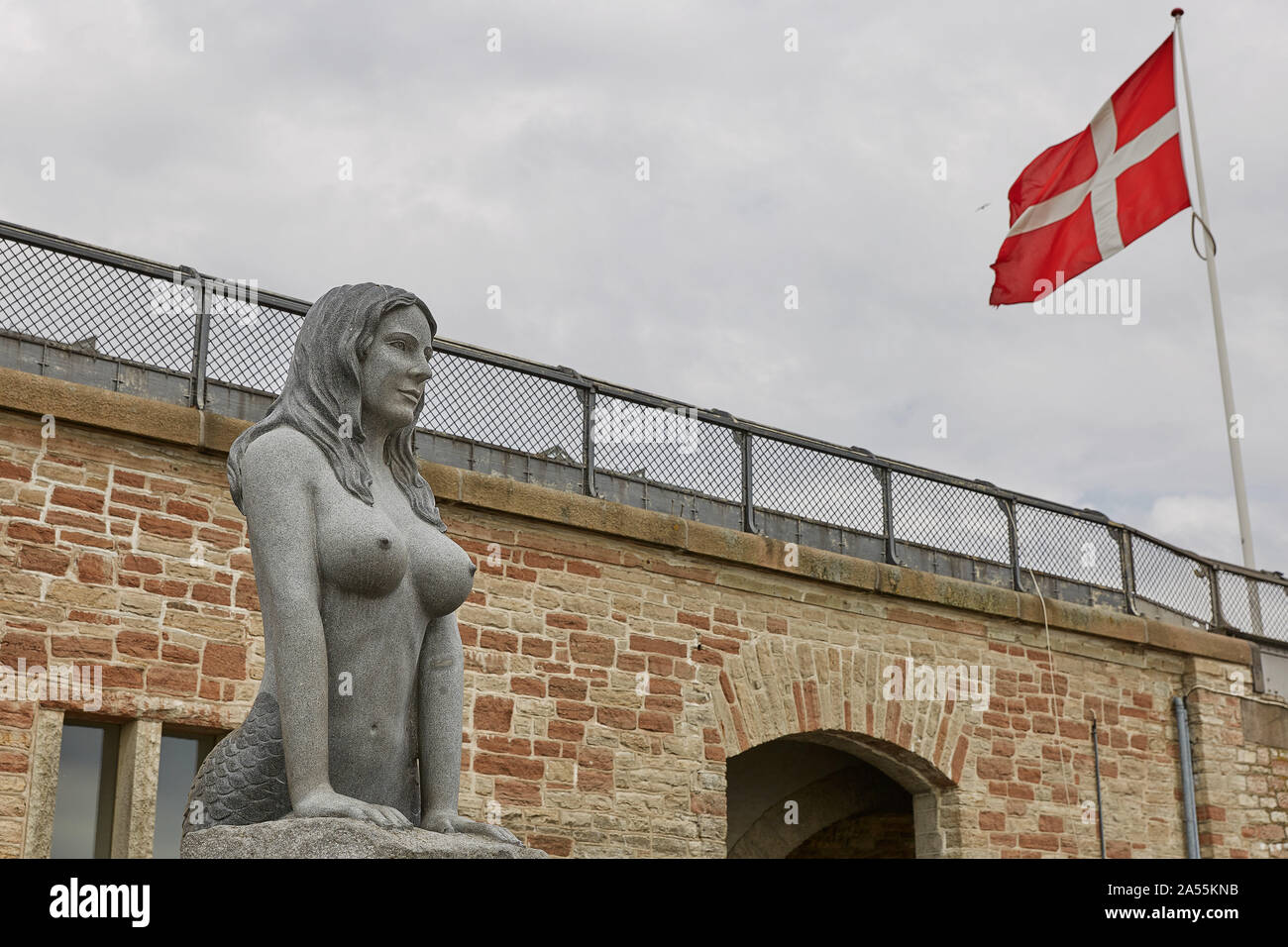 Kopenhagen, Dänemark - 28. JUNI 2017: Meerjungfrau und dänische Flagge in der Nähe der wichtigsten Hafen von Kopenhagen. Stockfoto