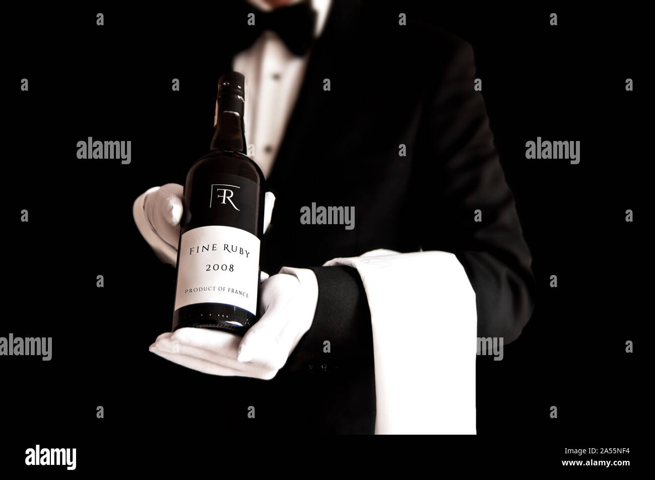 Kellner im Smoking, die eine Flasche Rotwein mit benutzerdefinierten  Etikette Stockfotografie - Alamy