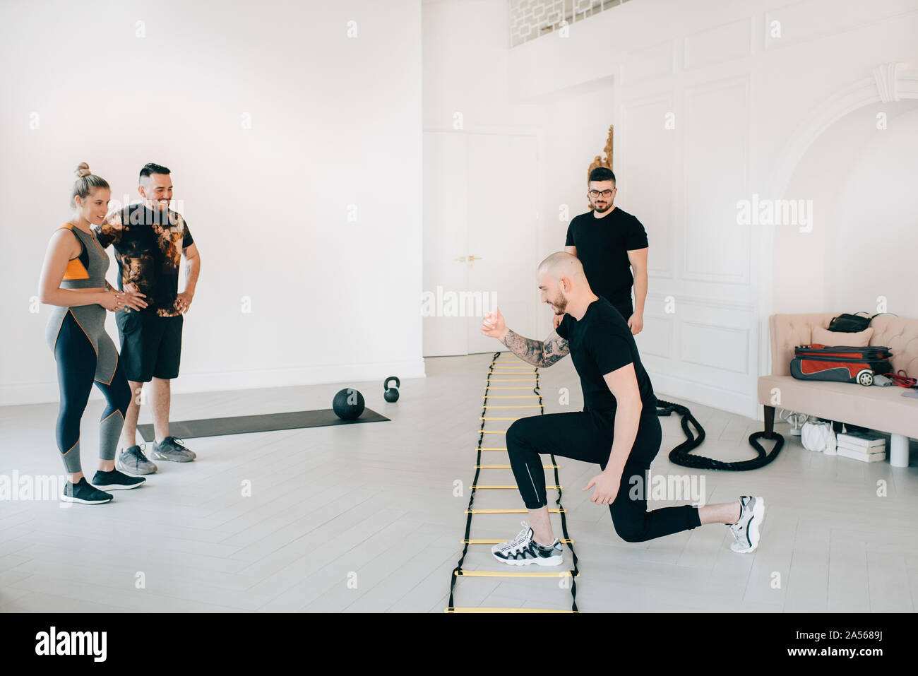 Paar beobachten Fitness Instructor mit Agility ladder im Studio Stockfoto