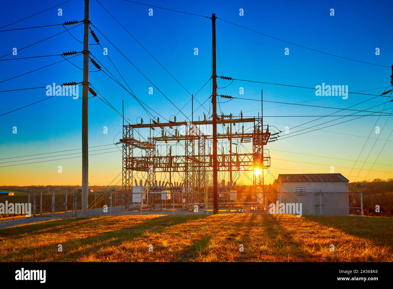 Elektrische Unterstation bei Sonnenuntergang mit blauen Himmel. Stockfoto