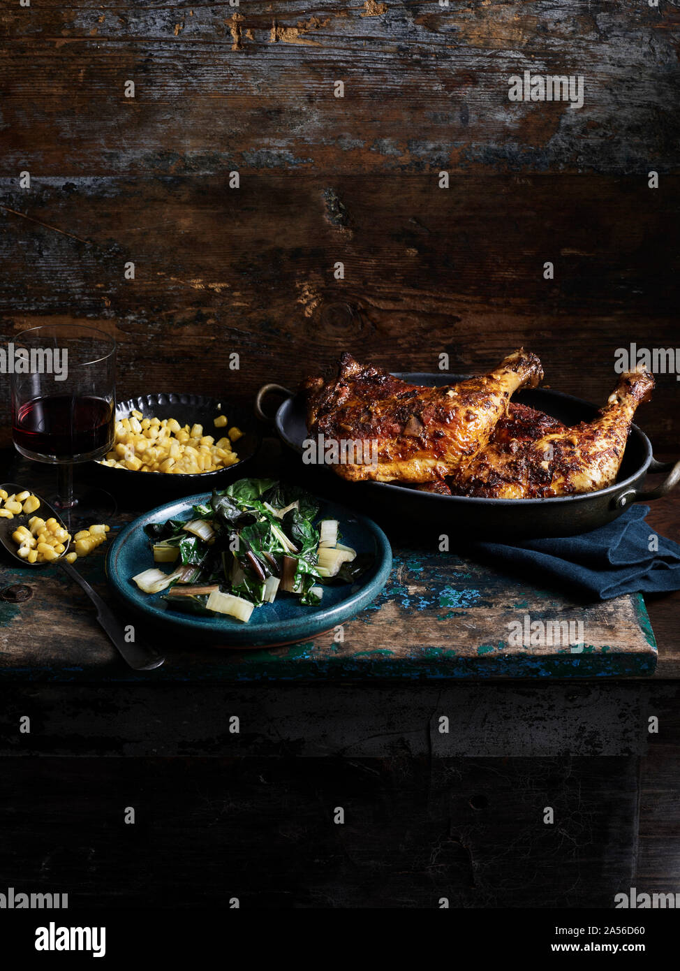 Rustikales Stilleben mit chipotle Chicken, Mais und Regenbogen Mangold auf hölzernen Tisch Stockfoto