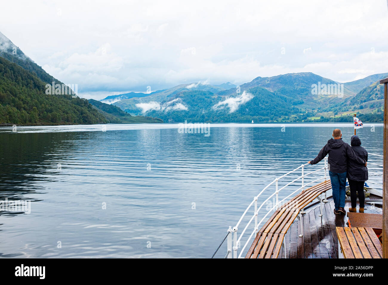 Ein Paar, die in der Ansicht von Ullswater Form der Rückseite eines Ullswater Dampfgarer. Ullswater, Lake District, Cumbria. Großbritannien Stockfoto