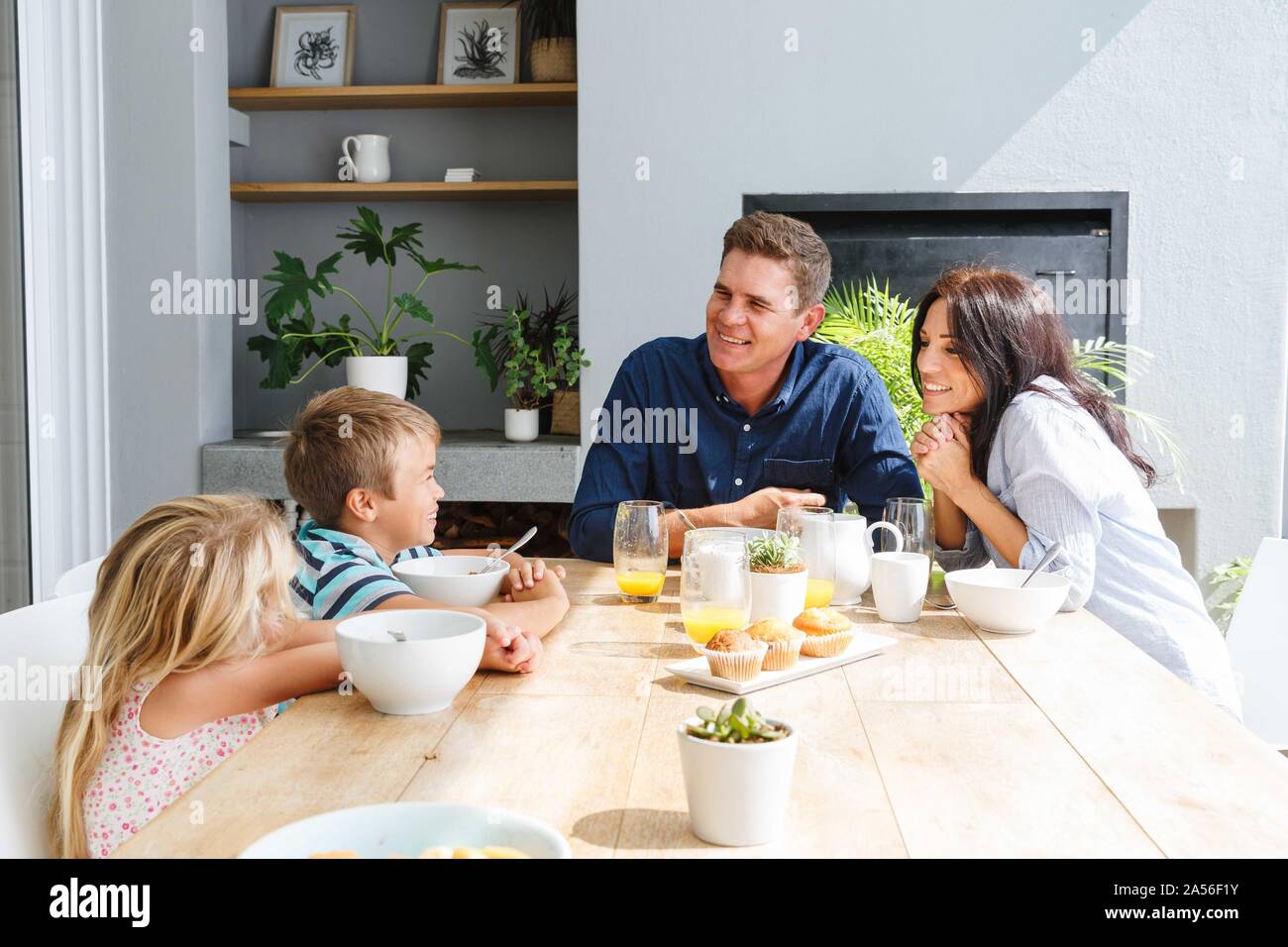 Eltern sprechen mit Kindern beim Mittagessen zu Hause Stockfoto
