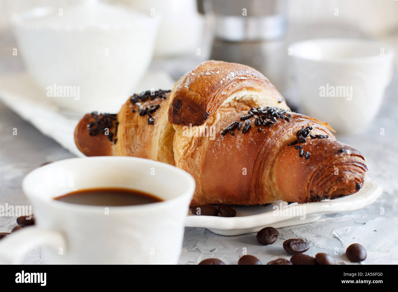 Frühstück mit Kaffee und Croissants in der Nähe mit Kaffee Bohnen Stockfoto