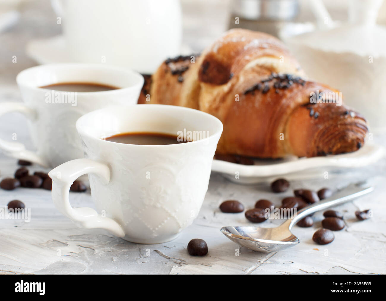 Frühstück mit Kaffee und Croissants in der Nähe mit Kaffee Bohnen Stockfoto