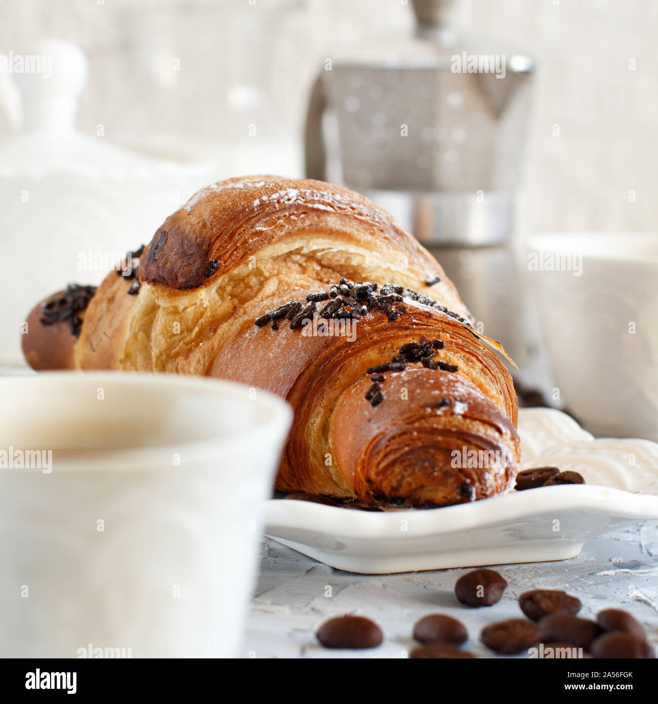 Frühstück mit Kaffee und Croissants in der Nähe mit Kaffee Bohnen Stockfoto