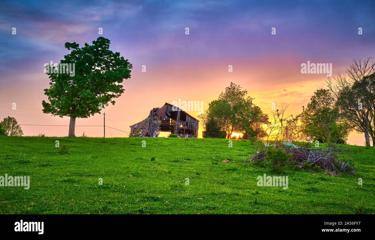 Dilapidate Scheune mit Sonnenuntergang. Stockfoto