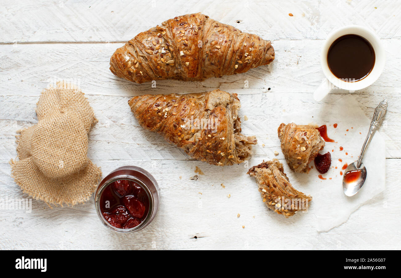 Frühstück mit Kaffee und Croissant, Ansicht von oben auf einem weißen Tisch Stockfoto