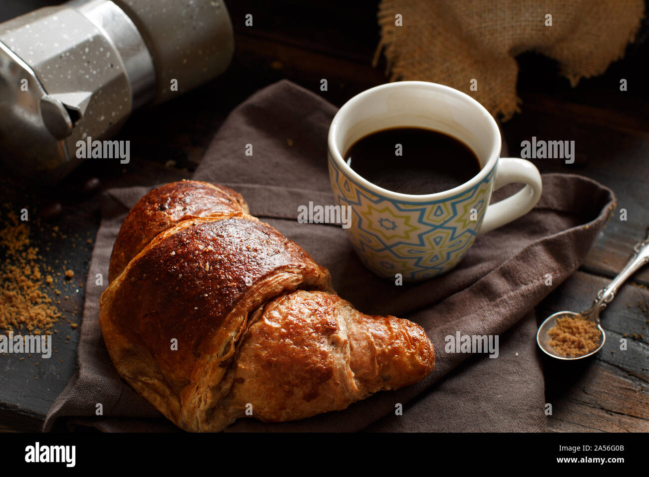 Frühstück mit Kaffee und Croissant auf einem dunklen Hintergrund Stockfoto