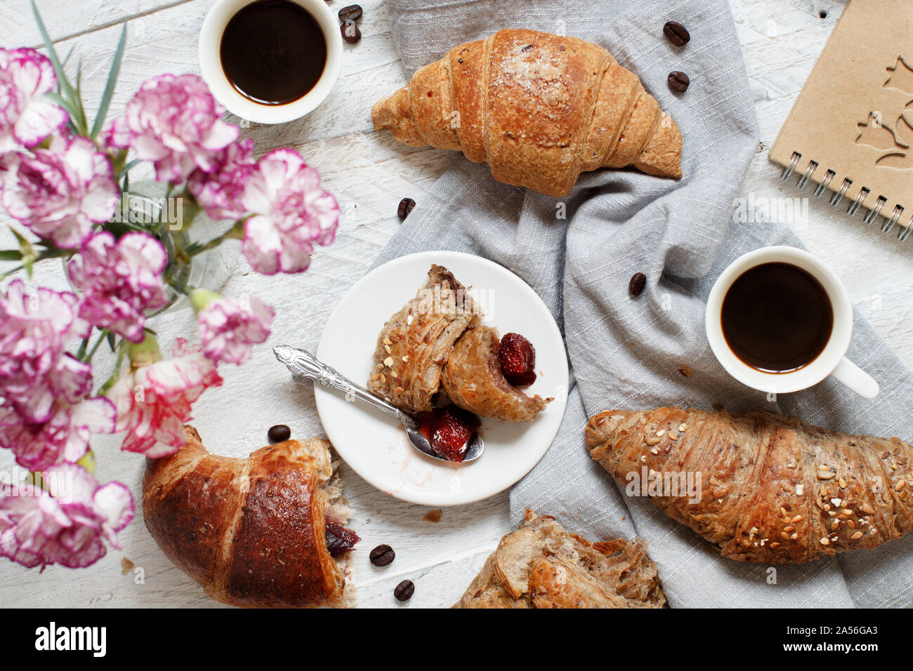Frühstück mit Kaffee und Croissants mit Erdbeermarmelade Nahaufnahme Stockfoto