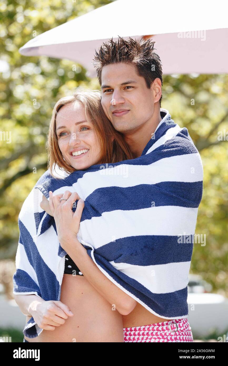 Paar verpackt in gestreiften Handtuch Sonne genießen. Stockfoto