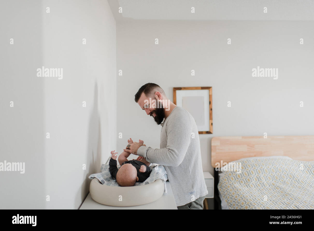 Junge Menschen, die den neuen Sohn Windel im Schlafzimmer Stockfoto
