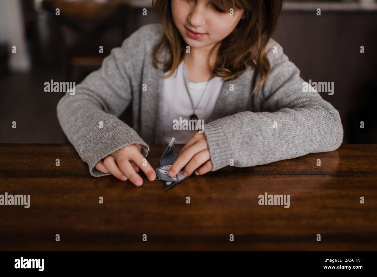 Mädchen am Tisch Falten Papier, Origami, Kopf und Schultern Stockfoto