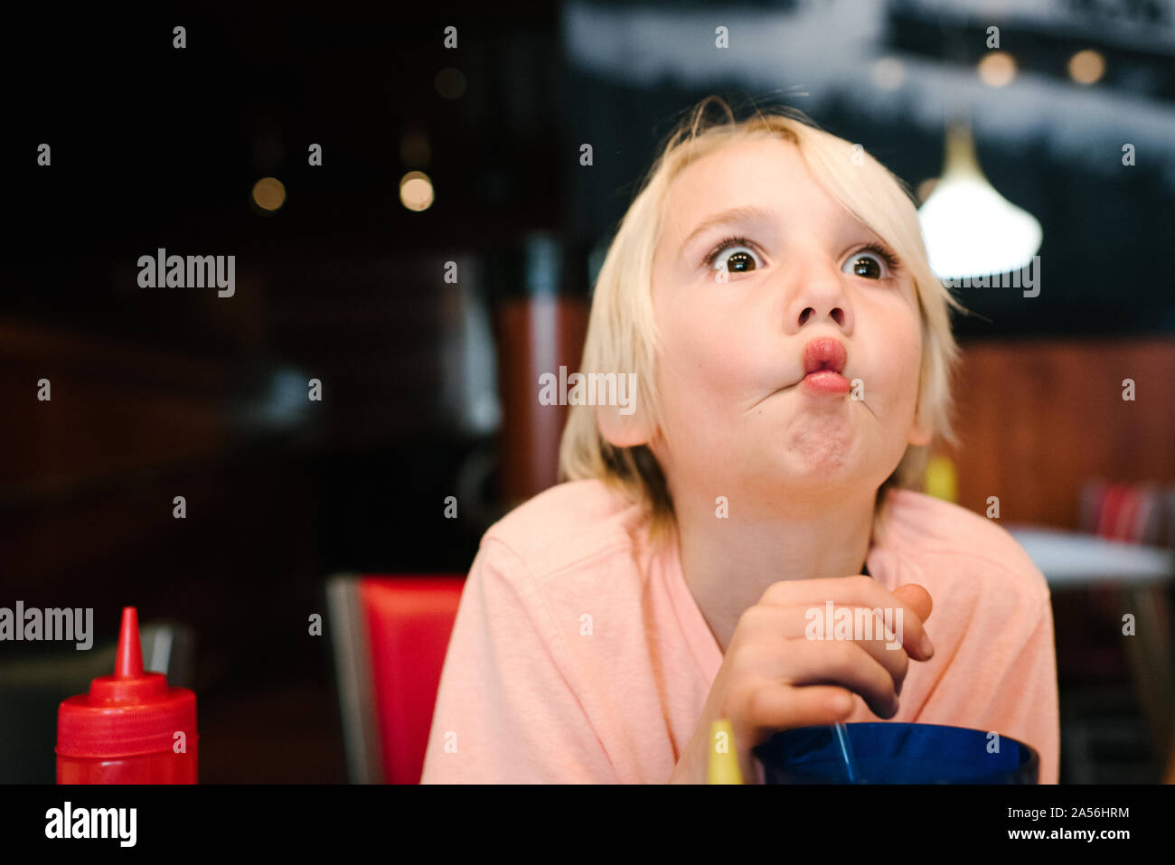 Blonde Junge im Airport cafe ziehen ein Gesicht, Kopf und Schultern Cute Stockfoto