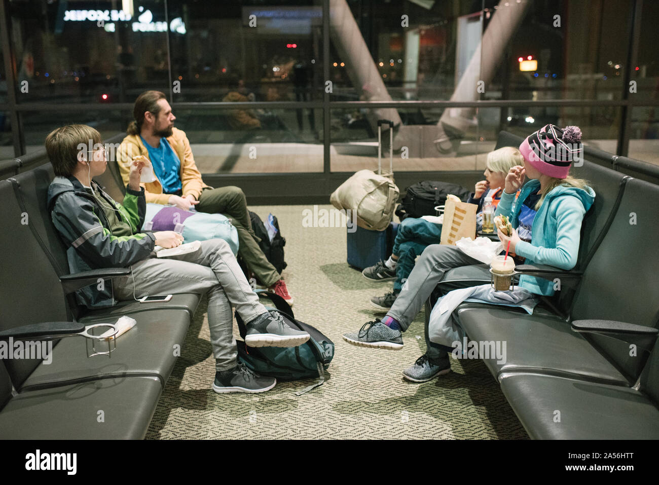 Reifer Mann mit Söhne und Tochter Warten im Flughafen Abflug Lounge Snacks essen Stockfoto
