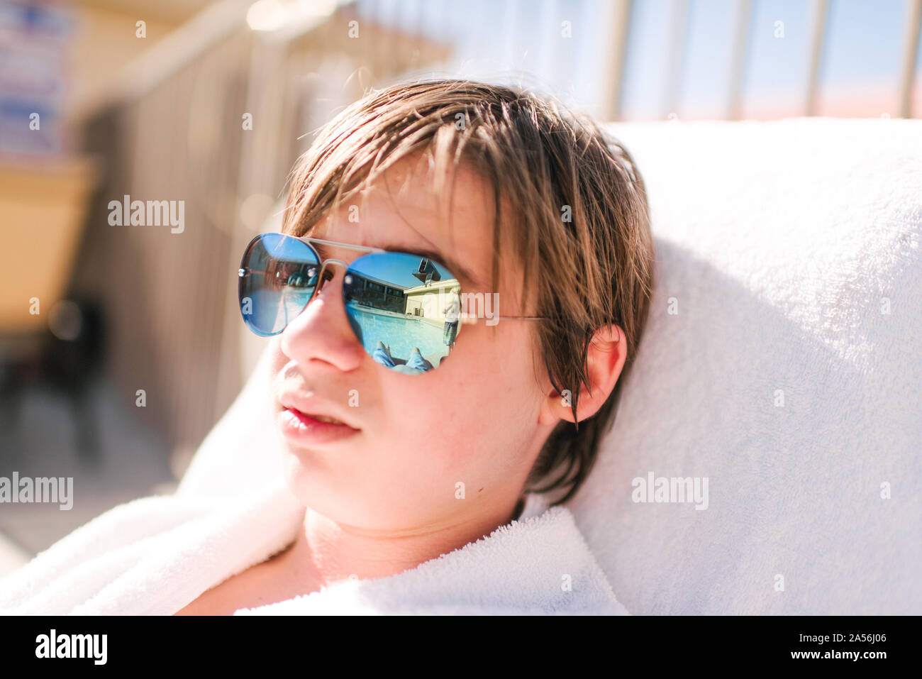 Cooler Teenager tragen Spiegelbild Sonnenbrille auf Sonnenliege am Hotel Pool, Kopf und Schultern, Las Vegas, Nevada, USA Stockfoto