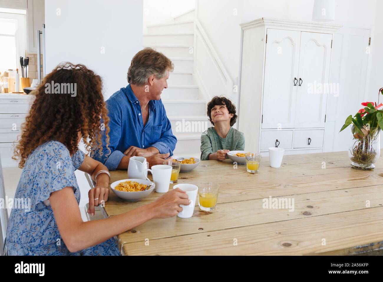 Eltern sahen Sohn Lächeln beim Frühstück zu Hause Stockfoto