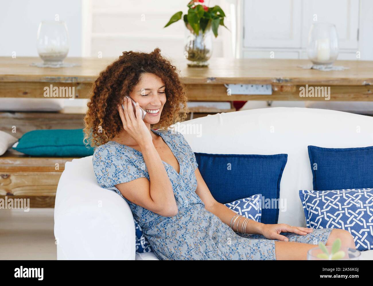 Frau Gespräch am Handy auf dem Sofa Stockfoto