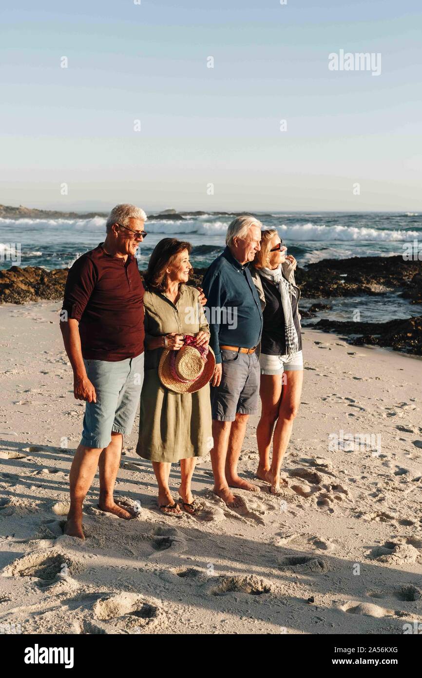 Ältere Ehepaare genießen Sonne am Sandstrand Stockfoto