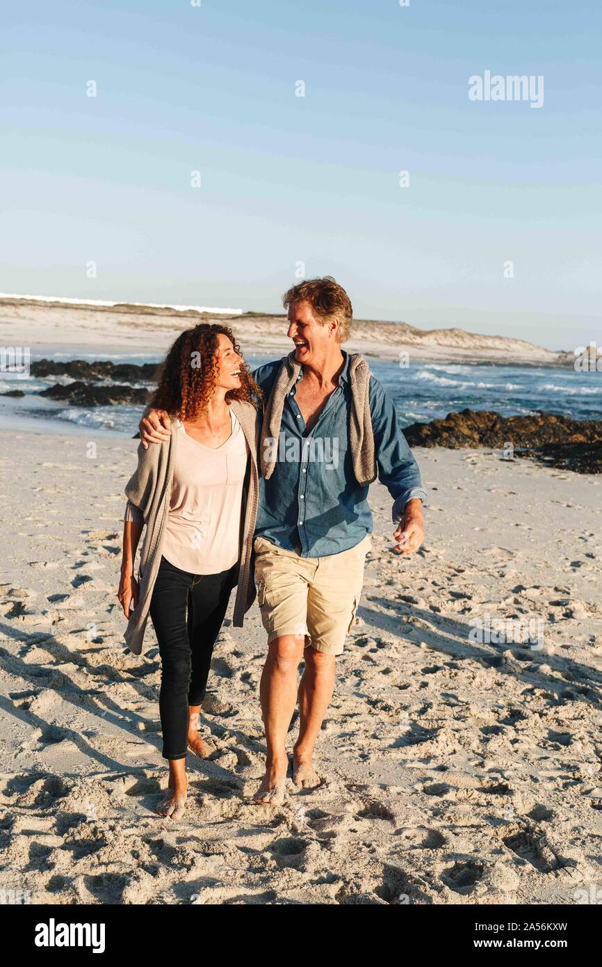 Paar nehmen zu Fuß am Sandstrand Stockfoto