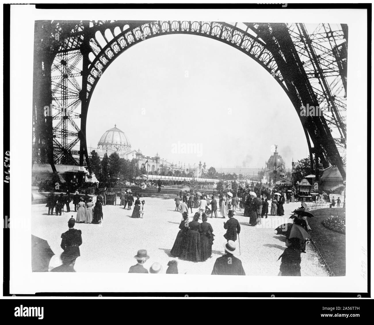 Blick auf den Palast der Schönen Künste auf der linken und der zentralen Kuppel auf der rechten Seite, durch die Basis des Eiffelturm gesehen, mit Menschen zu Fuß unter dem Turm, Paris Exposition, 1889 Stockfoto