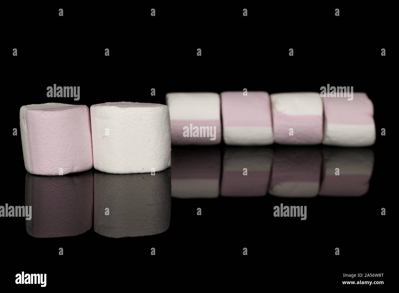 Gruppe von sechs ganze süsse Pastell Marshmallow auf schwarzem Glas isoliert Stockfoto