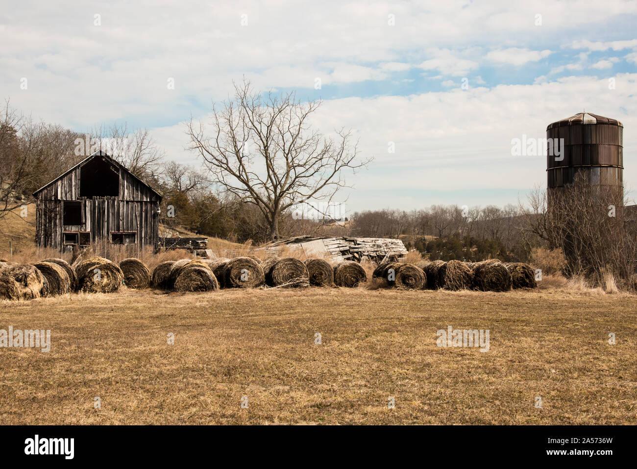 Bauernhof mit Silo und Heuballen aufgegeben. Stockfoto