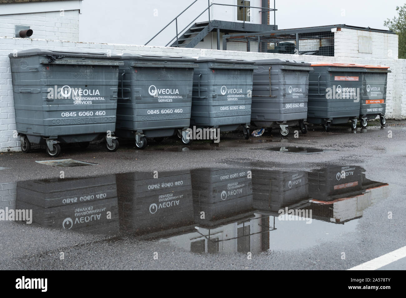 Reihe von Veolia Abfallbehälter und recycling Bins in einer Pfütze spiegelt, Großbritannien Stockfoto