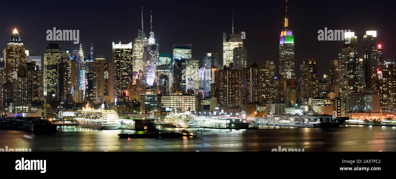 Gebäude in einer Stadt ist abends beleuchtet, den Hudson River von Manhattan, Manhattan, New York City, New York State, USA Stockfoto