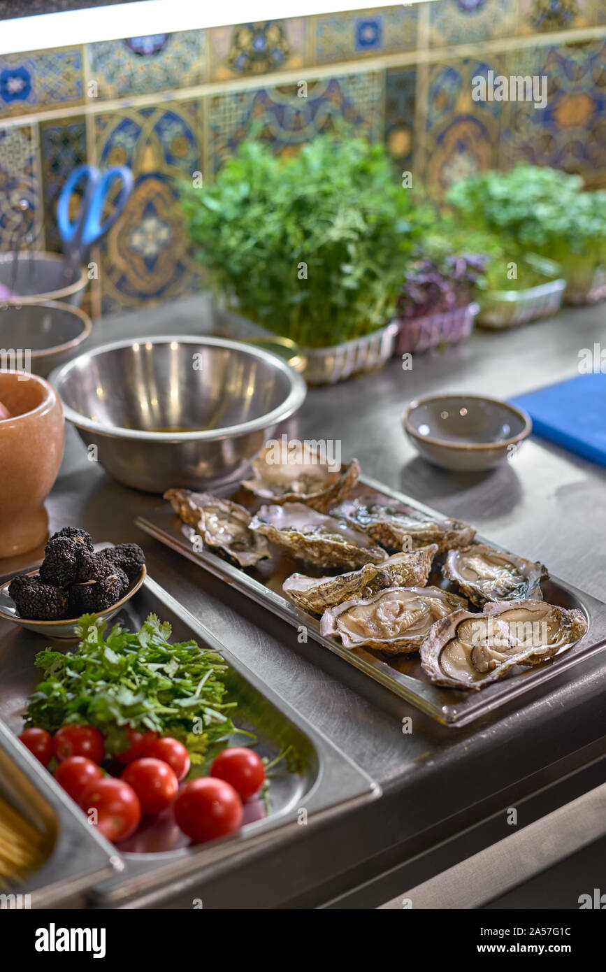 Essen Konzept. Austern und Zutaten zu den Teller auf den Tisch in der Küche. Der Prozess der Spaghetti mit Meeresfrüchten. Stockfoto