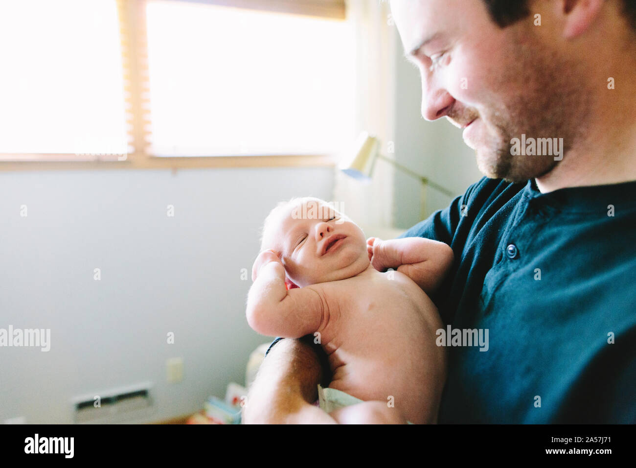 Einen neuen Papa hält sein neugeborenes Baby Boy, während er erstreckt sich Stockfoto