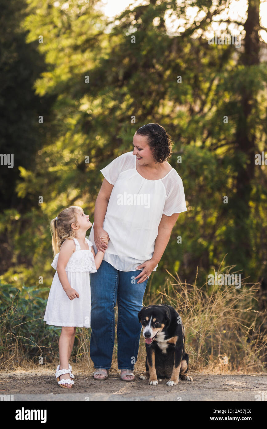 Junge Mädchen und Mama sich mit Familie pup Lächeln an ihren Füßen Stockfoto