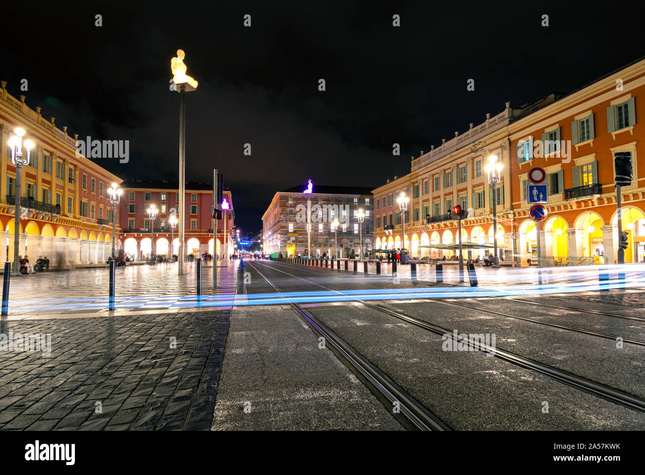 Auto Scheinwerfer machen Licht Trail von lange Belichtung wie das Kreuz Straßenbahnschienen spät in der Nacht in der Place Massena in der Altstadt von Nizza, Frankreich. Stockfoto