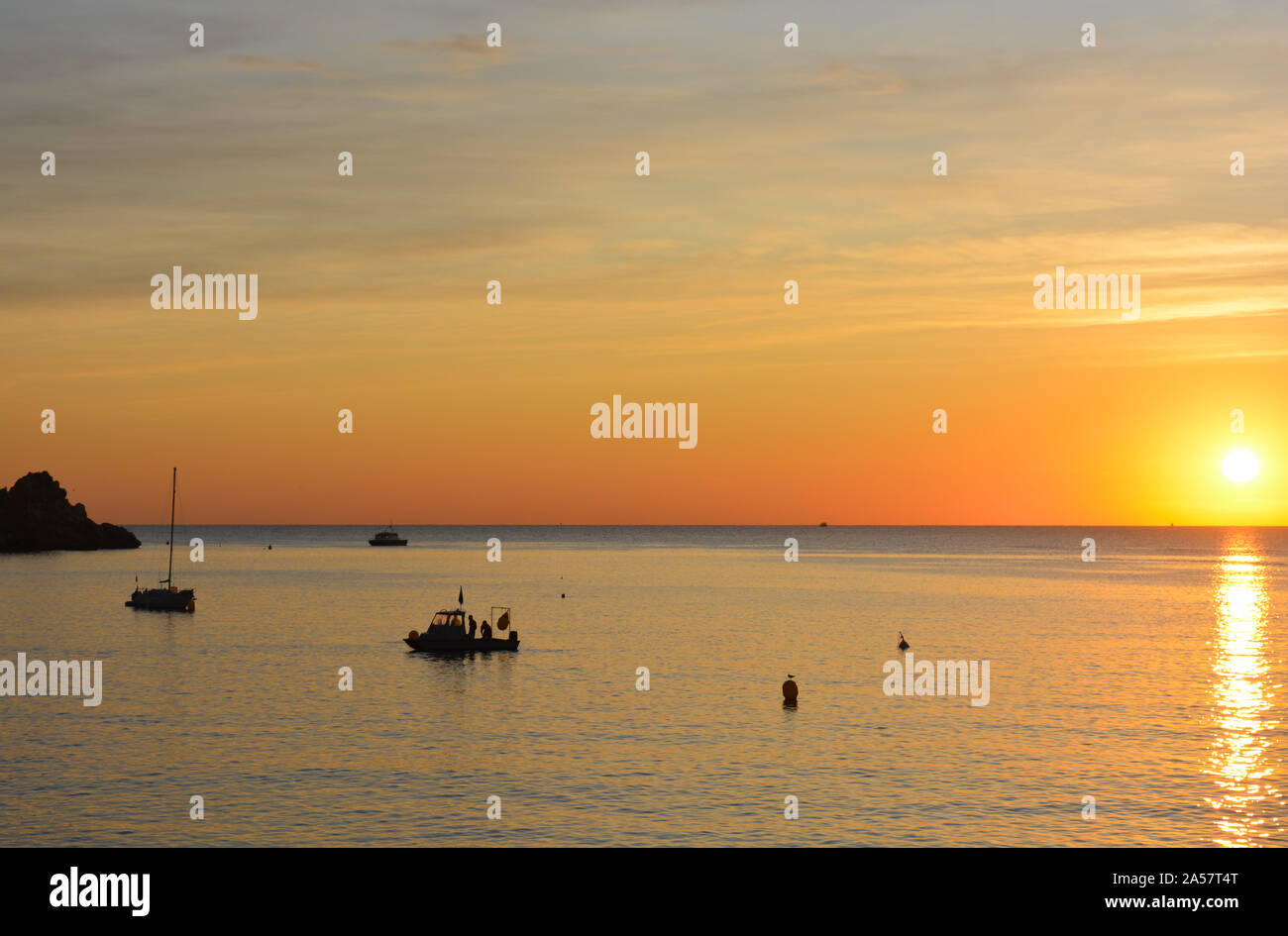 Yacht und Boot von der Landspitze verankert, Cabo La Nao, Silhouette bei Sonnenaufgang Stockfoto